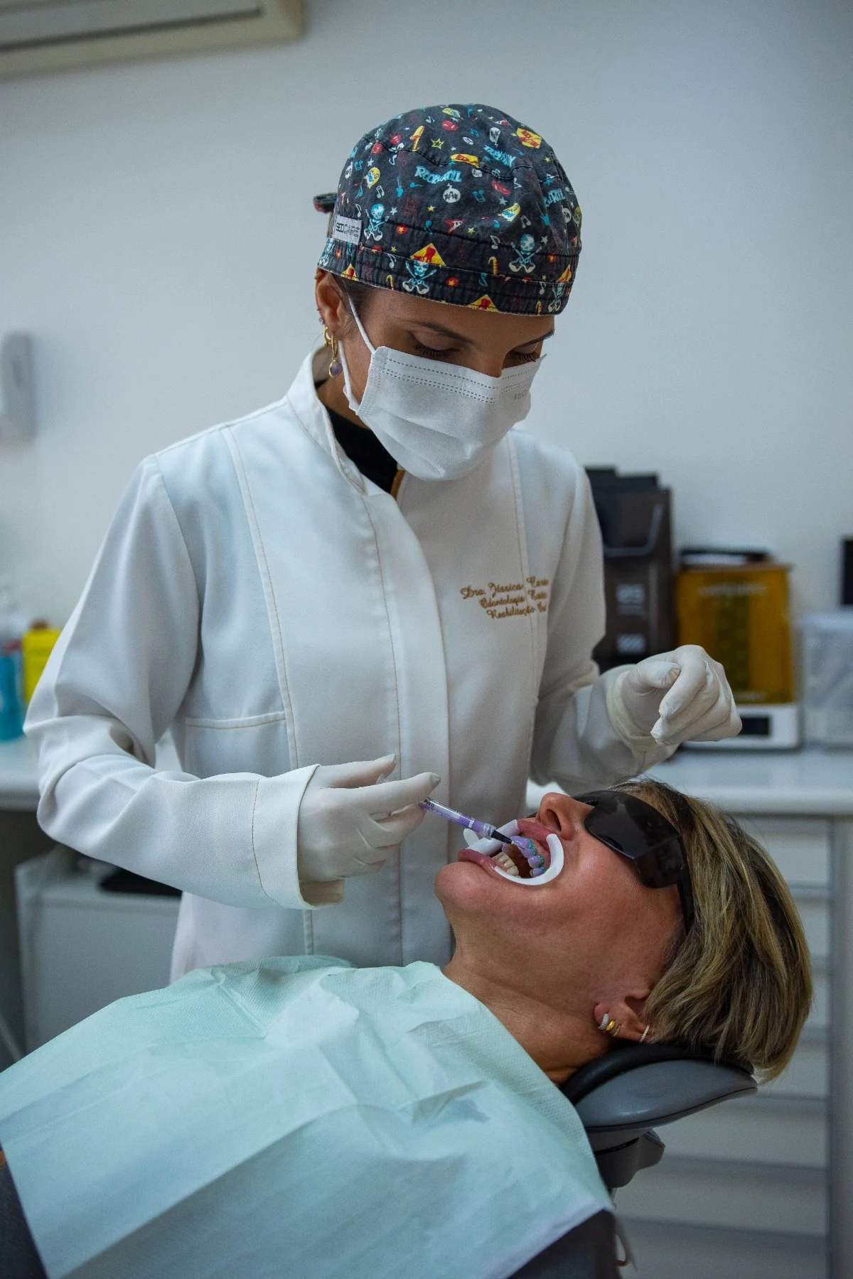 Aplicação de gel clareador com afastador e óculos de proteção